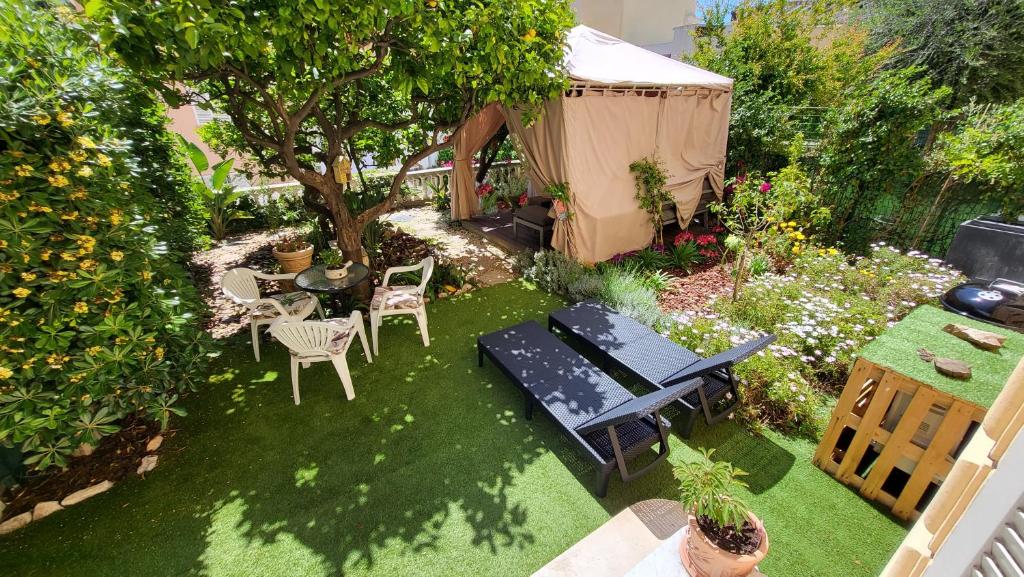 蒙特卡罗Super Flat, Garden. Bnbrickeys的一个带桌椅和帐篷的花园