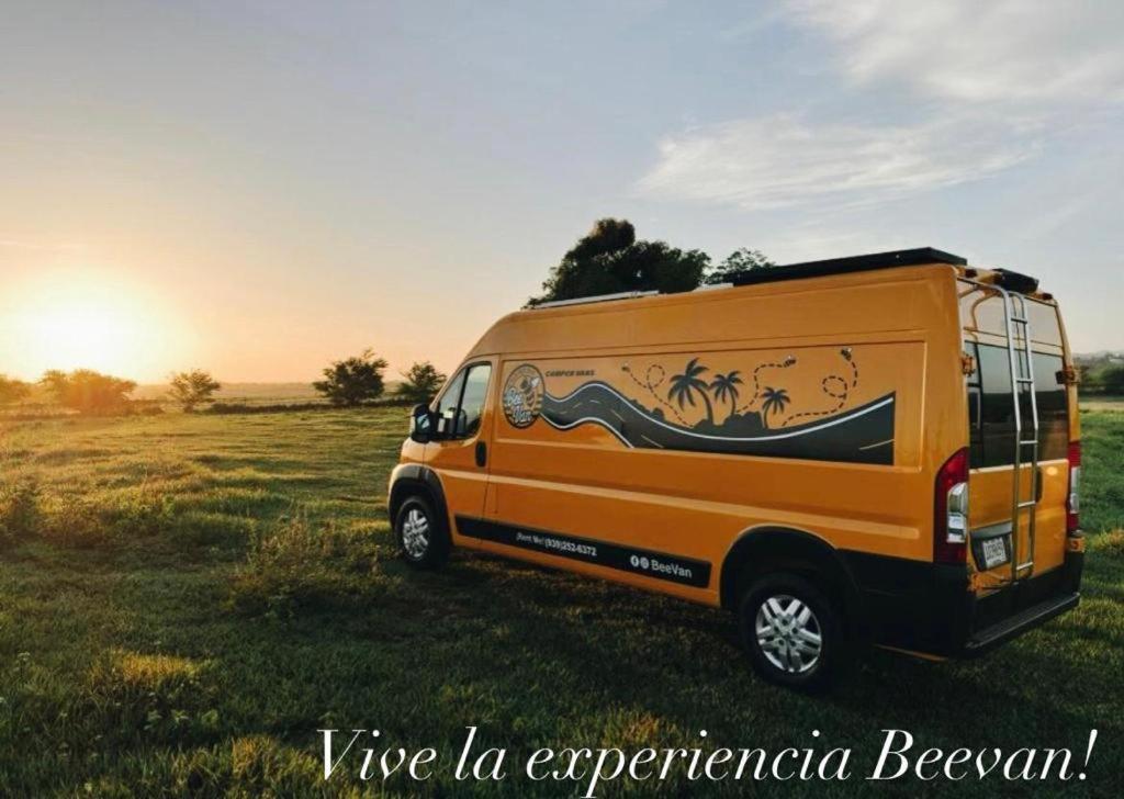 阿瓜迪亚BeeVan的一辆橘子面包车停在一个有日落的田野里