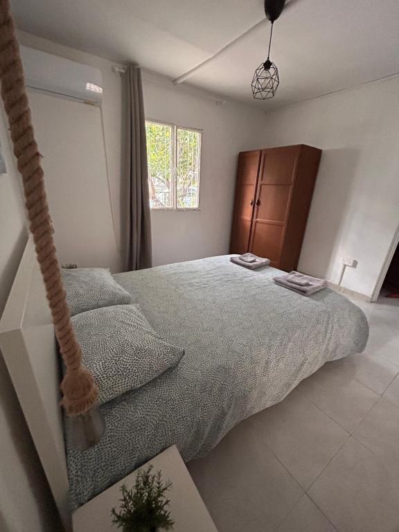 利马索尔Avra House的一间卧室配有一张大床和一张挂床。