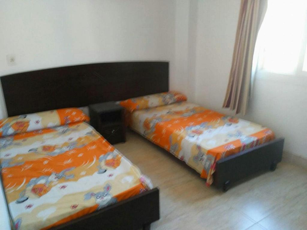 艾因苏赫纳شاليه بقرية كورنادو السخنه的一间卧室配有两张床和一张床套