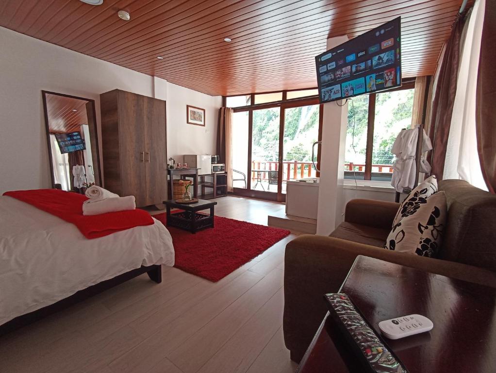 巴尼奥斯J旅馆的一间卧室配有一张床,客厅配有沙发
