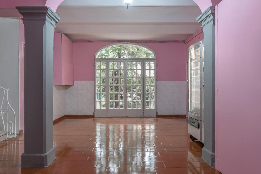 博洛尼亚Saragozza Apartments的一间空房间,设有粉红色的墙壁和拱门
