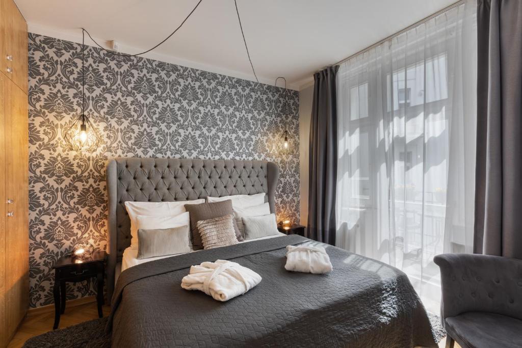 布拉格Romantic Balcony Apartment in Old Town的一间卧室配有一张床,上面有两条毛巾