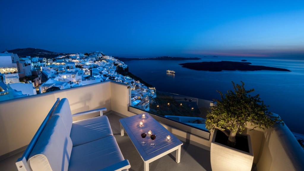 菲罗斯特法尼Damigos Caldera World的阳台配有蓝色的家具,享有海景。