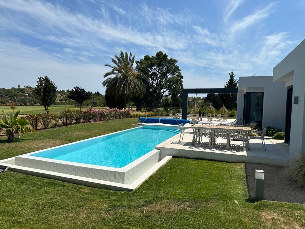 西尔韦斯Pestana Silves Golf & Residences的庭院内带桌椅的游泳池