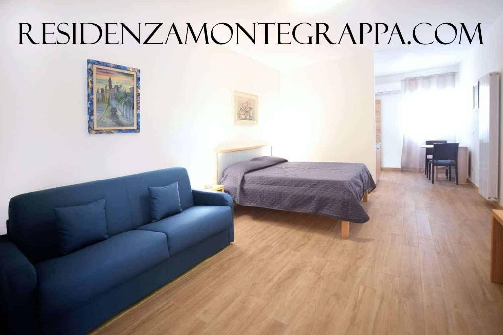 佩斯基奇Residenza Montegrappa的客厅配有蓝色的沙发和床。