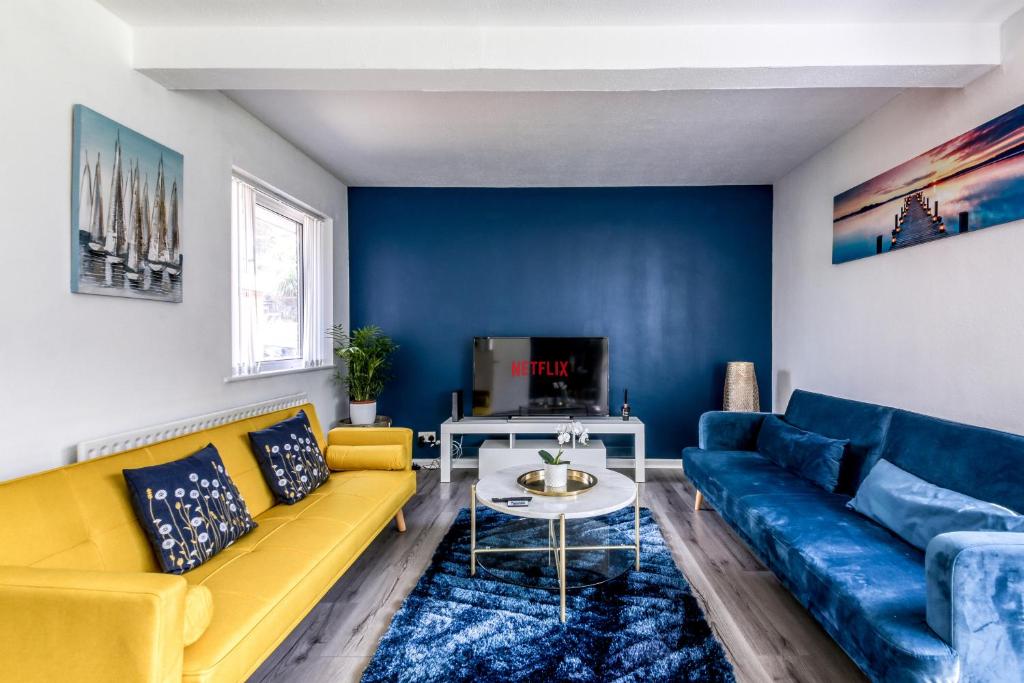 克罗伊登Contemporary 4 bedroom detached house with parking and city links的客厅设有黄色沙发和蓝色的墙壁。