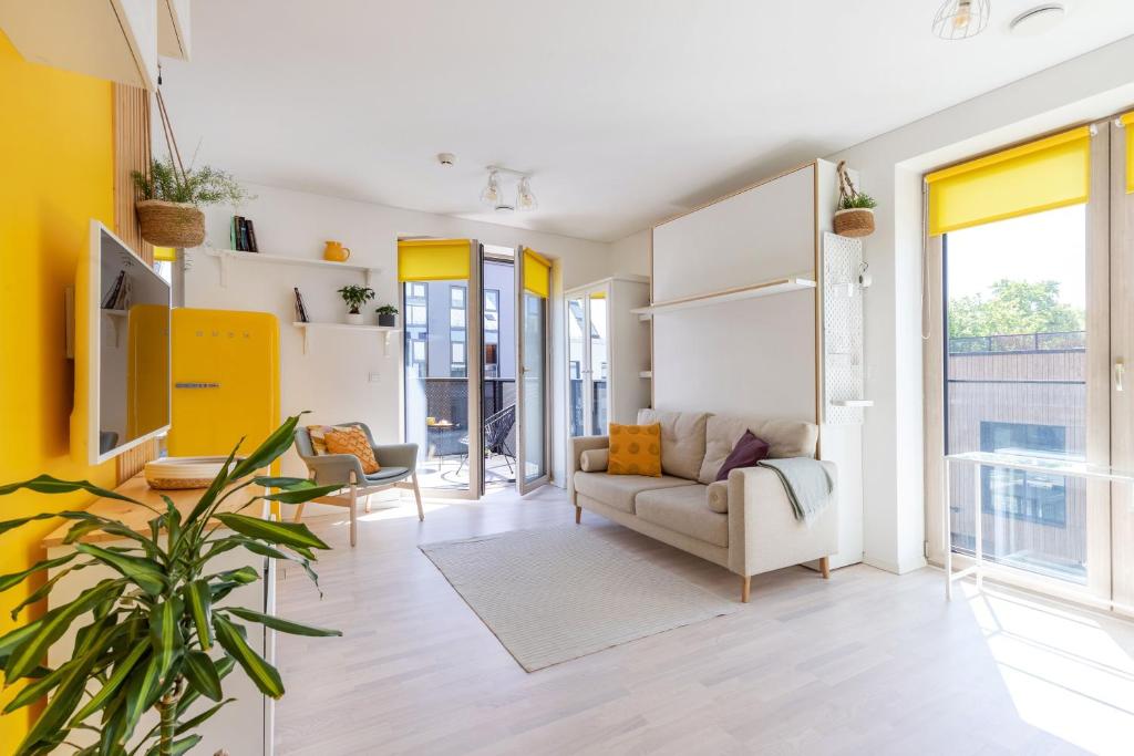 维尔纽斯Yellow Studio Paupys的客厅设有黄色的墙壁和沙发