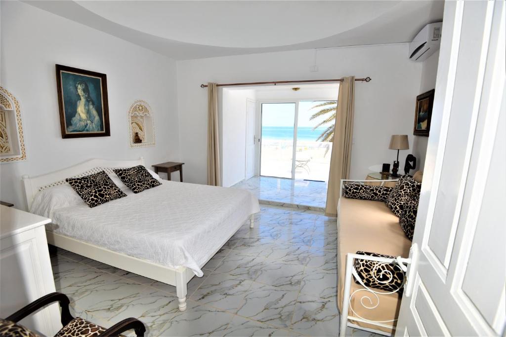 杰尔吉斯VILLA KIKA ZARZIS, LOCATION CHAMBRES D'HÔTES en TUNISIE的一间卧室配有一张床,享有海景