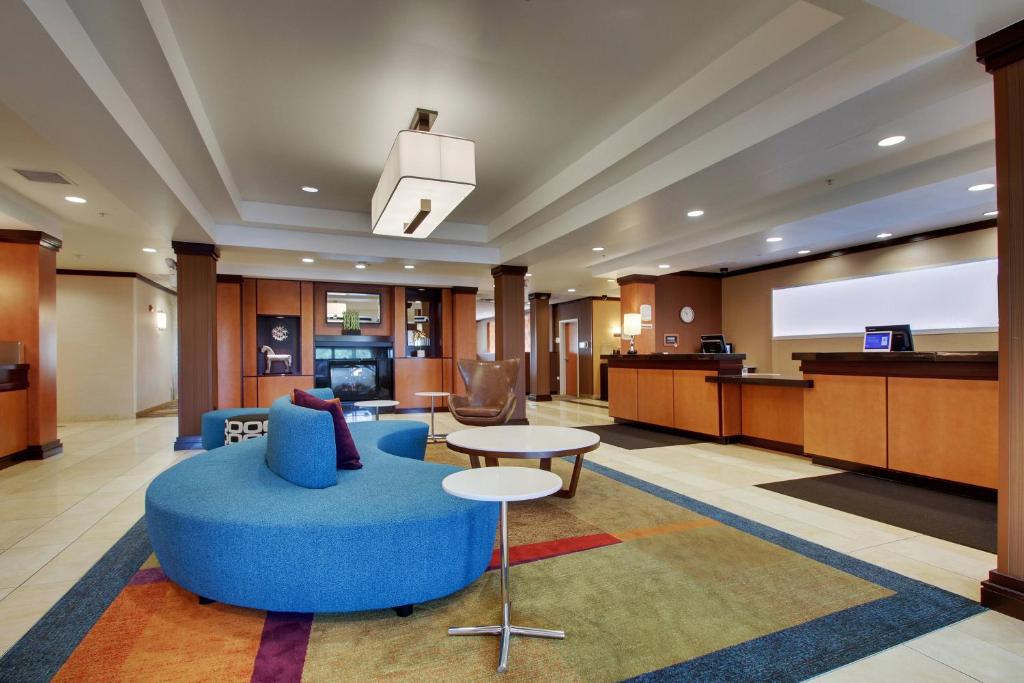渥太华Fairfield Inn & Suites by Marriott Ottawa Starved Rock Area的酒店大堂设有蓝色的沙发和屏幕