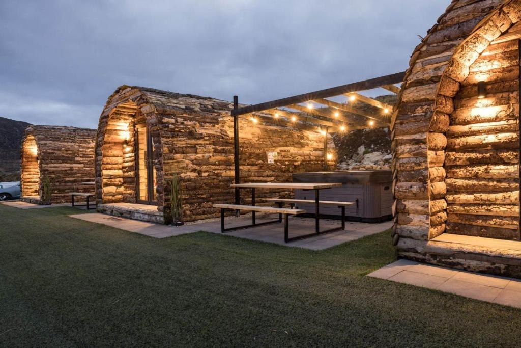BannvaleGreenview Glamping Pods的石头建筑,带野餐桌和灯