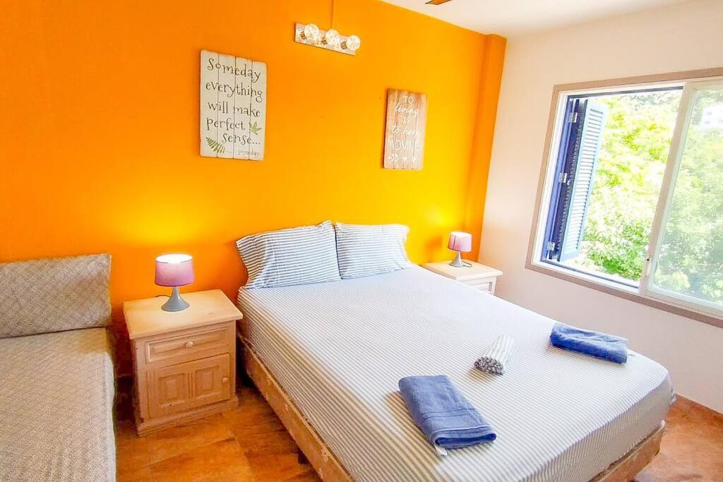 赛姆Dep 304a En Casablanca Linda Suite Petfriendly cerca de todo的一间卧室拥有橙色的墙壁、一张床和窗户