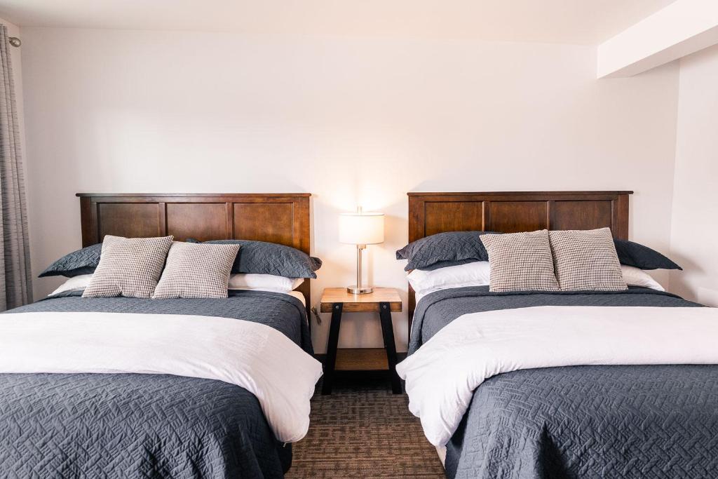 Delta JunctionAlaska Frontier Inn的配有两盏灯的房间的两张床