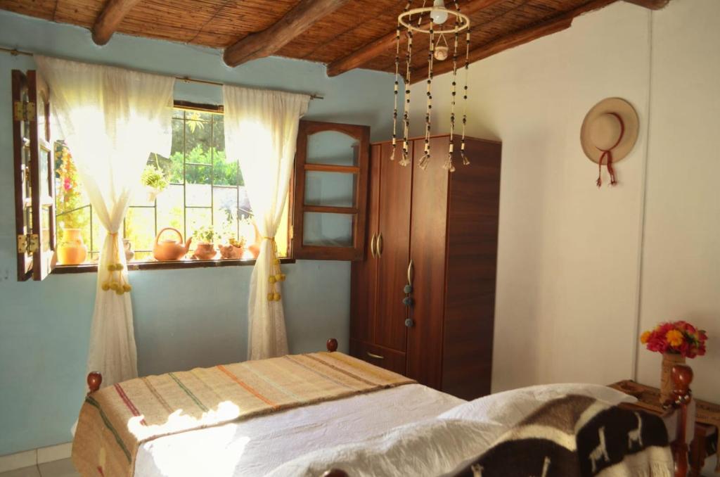 胡阿卡勒拉La Casita de la Abuela Huacalera - Quebrada de Humahuaca的一间卧室设有一张床和一个窗口
