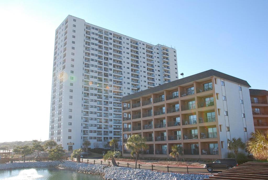 默特尔比奇美特尔海滩度假酒店的一座大型公寓楼,前面设有一个游泳池