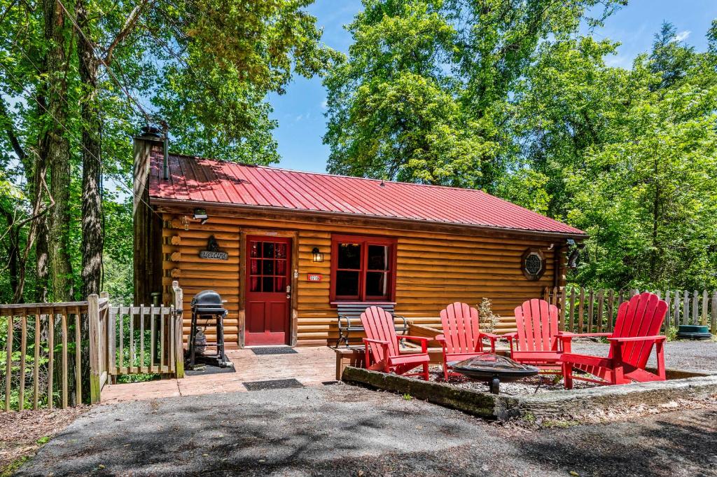 鸽子谷Cozy cabin with a mountain view的小木屋配有红色椅子和桌子