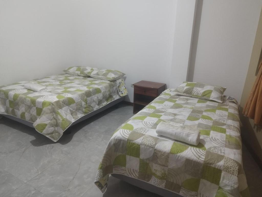 巴克里索莫雷诺港Casa D'Lucas的一间卧室设有两张床和床头柜