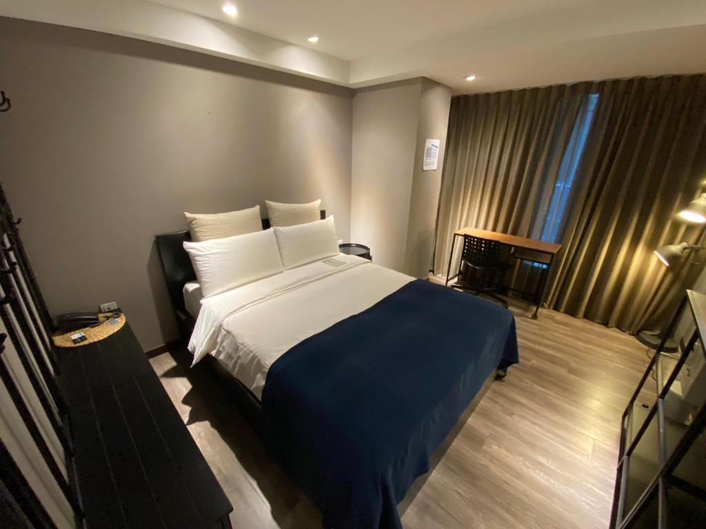 台北优美饭店-双连MRT的一间卧室配有一张带蓝色毯子的大床