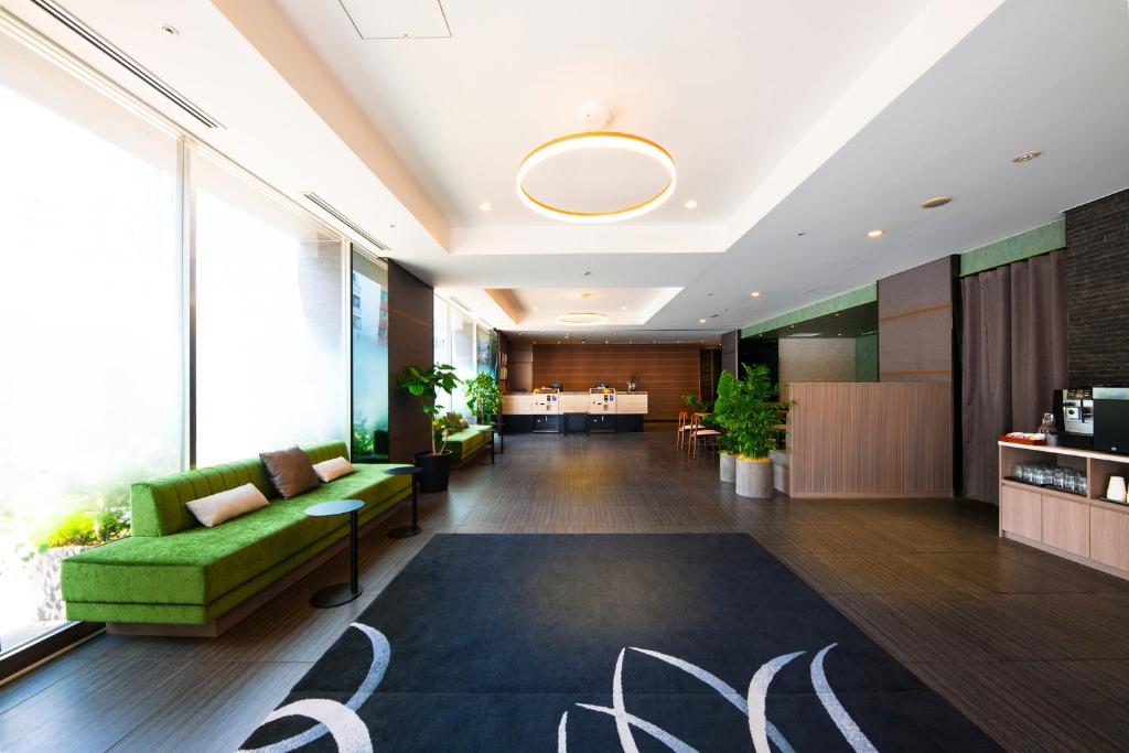 东京东京九段下芬迪别墅酒店的办公室大堂设有绿色沙发和地毯