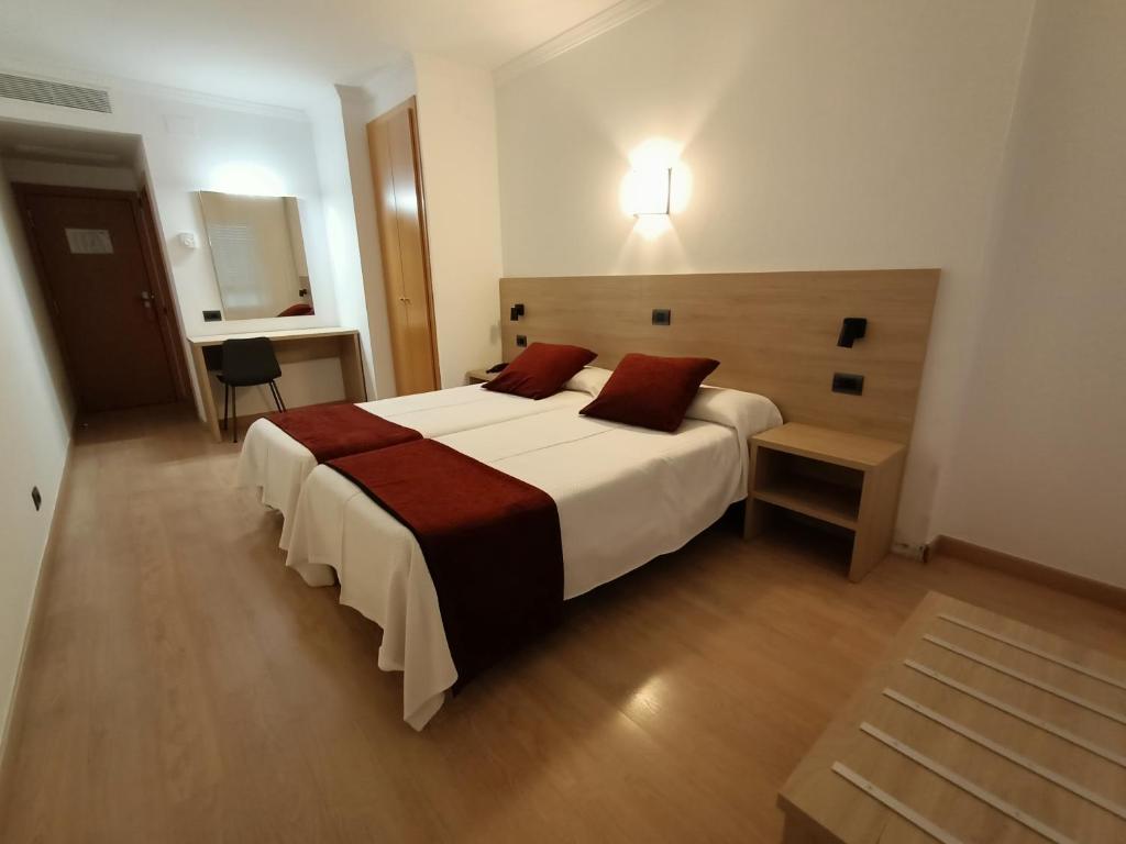 维罗维-德欧纳维洛比酒店的卧室配有带红色枕头的大型白色床