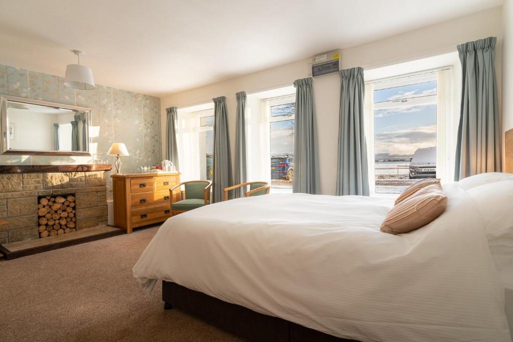 托伯莫里Harbour Guest House的一间卧室设有一张床和一个大窗户