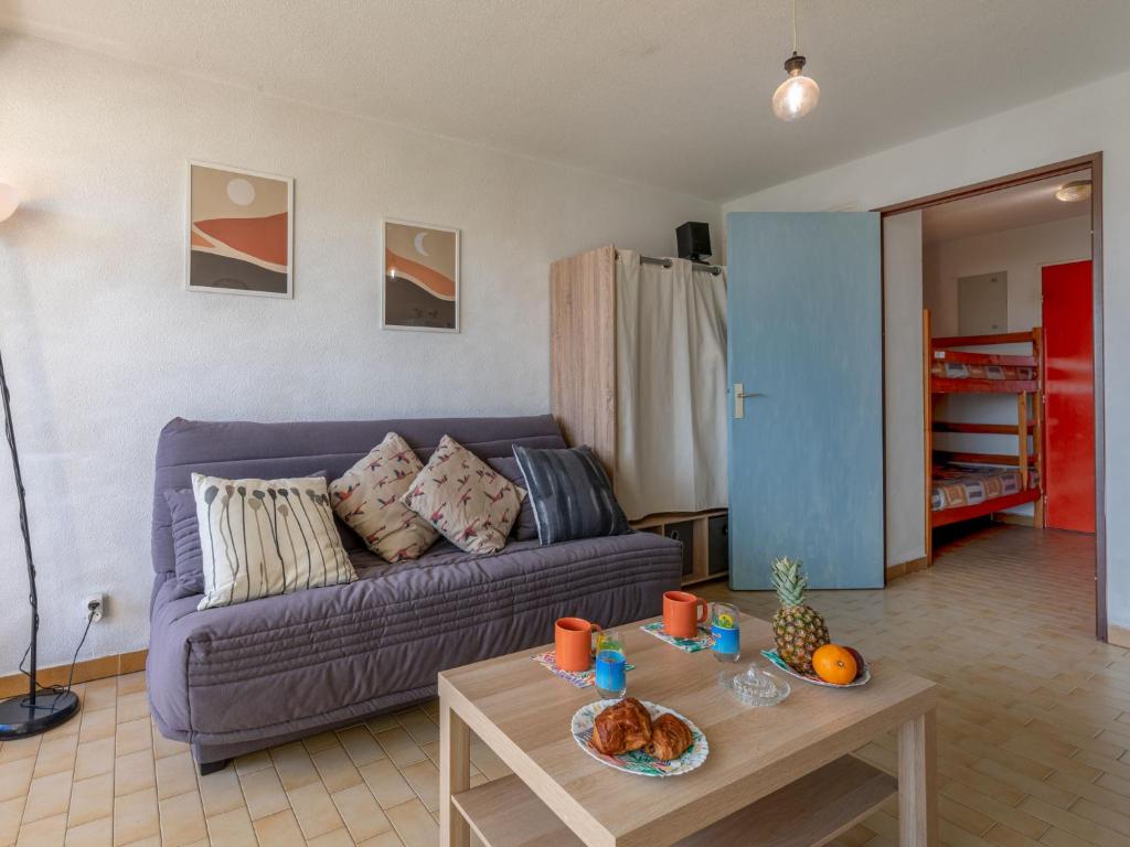 勒格罗-迪鲁瓦Studio Los Amigos-6 by Interhome的客厅配有紫色沙发和桌子