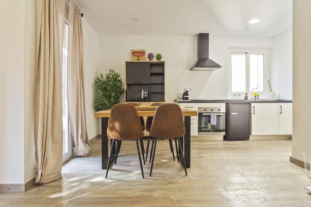 巴塞罗那勒哥尔特白色公寓酒店的厨房配有木桌和两把椅子