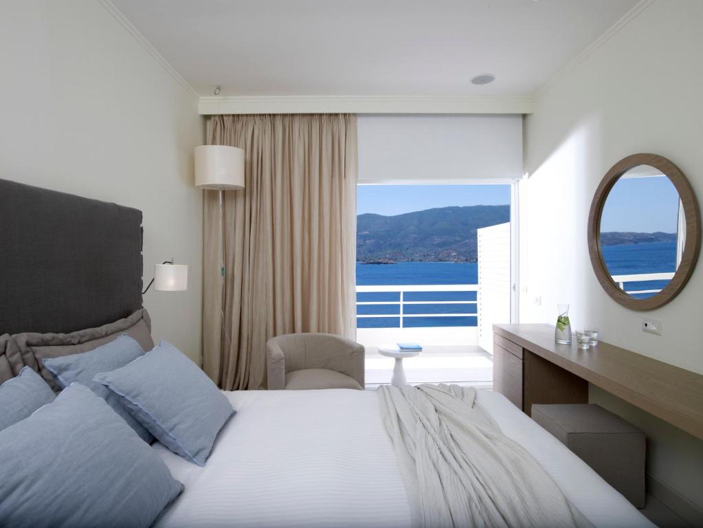 波罗斯Sirene Blue Luxury Beach Resort的一间卧室配有一张大床和镜子