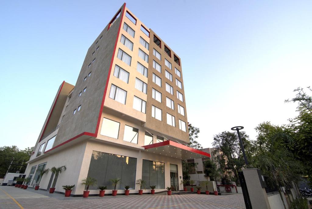 斋浦尔7 Apple Hotel Pratap Nagar, Jaipur的一座高大的建筑,上面有一条红色条纹