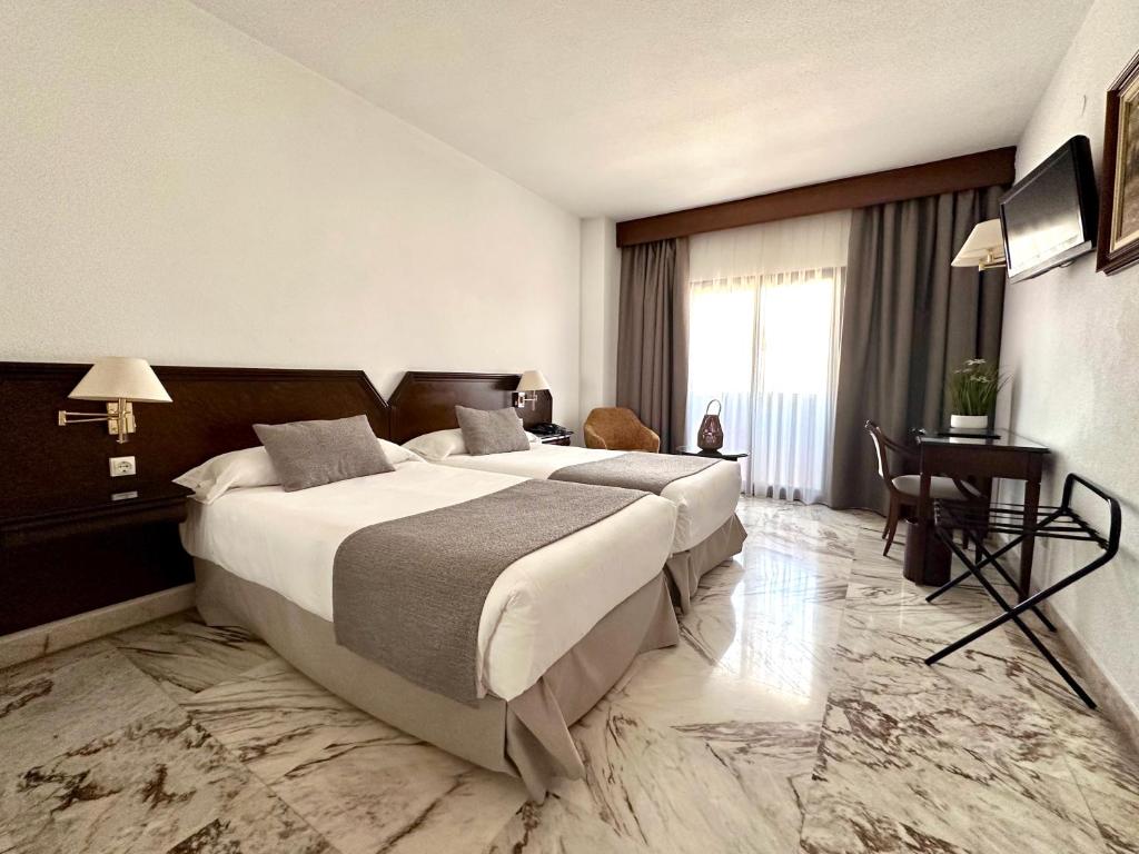 瓦伦西亚图里亚酒店的酒店客房设有一张大床和一张书桌。