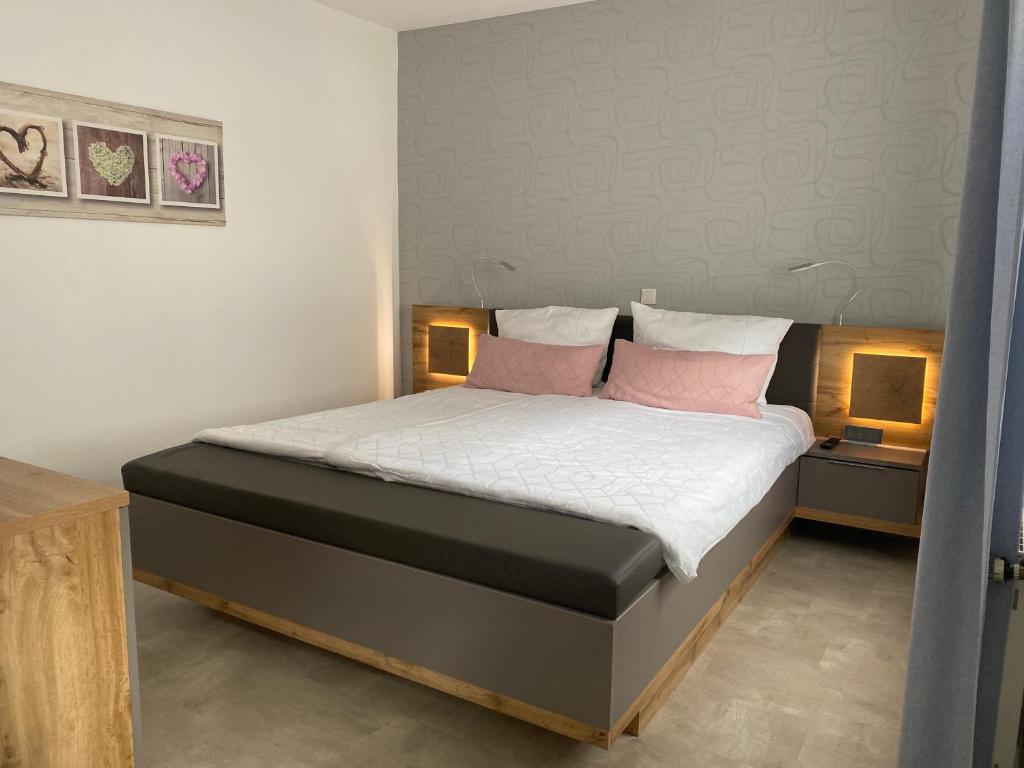 策尔廷根-拉蒂希Ferienwohnung Junglen an der Mosel的一间卧室配有一张带两个粉红色枕头的床