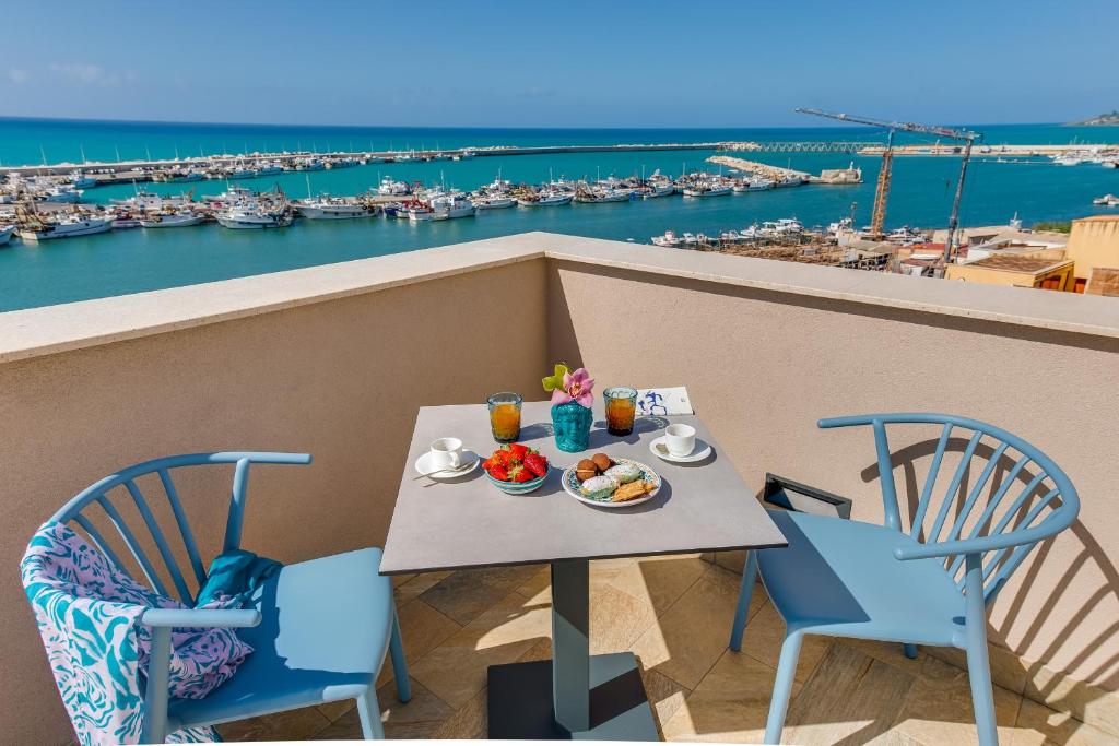 夏卡RoccaRegina Hotel的阳台上的餐桌,享有海港景色