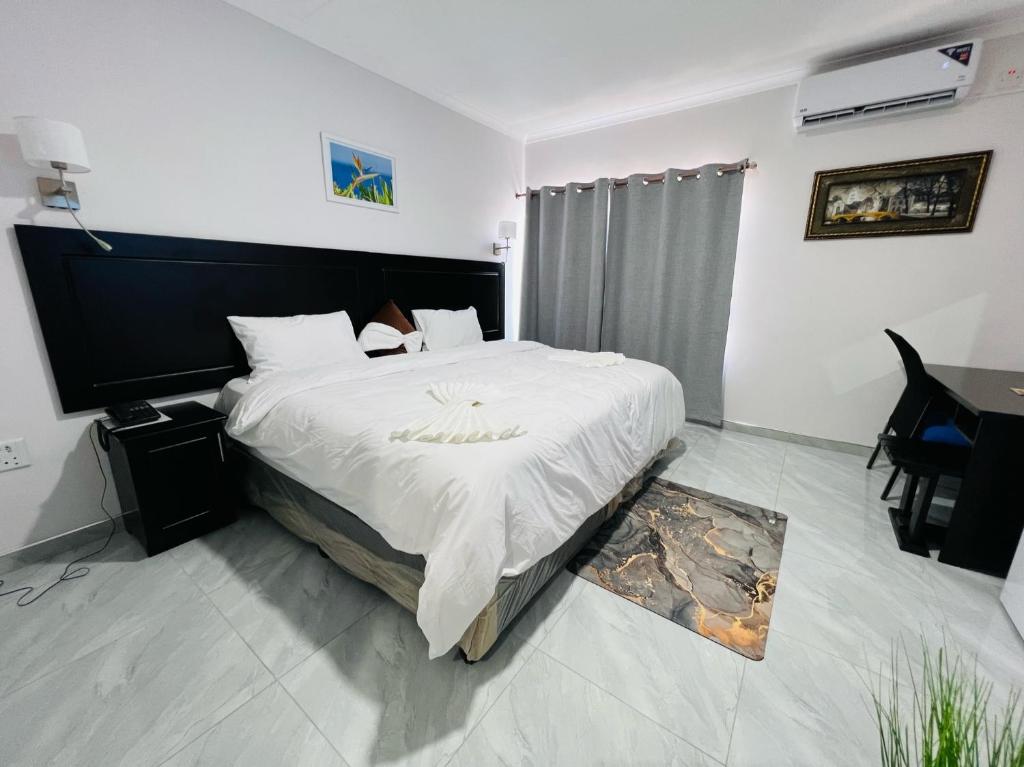 马翁Maun Nest Hotel的一间卧室配有一张大床和一张桌子
