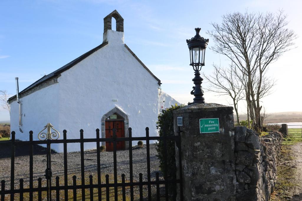 TubberThe Burren Art Gallery built in 1798的栅栏前有路灯的教堂
