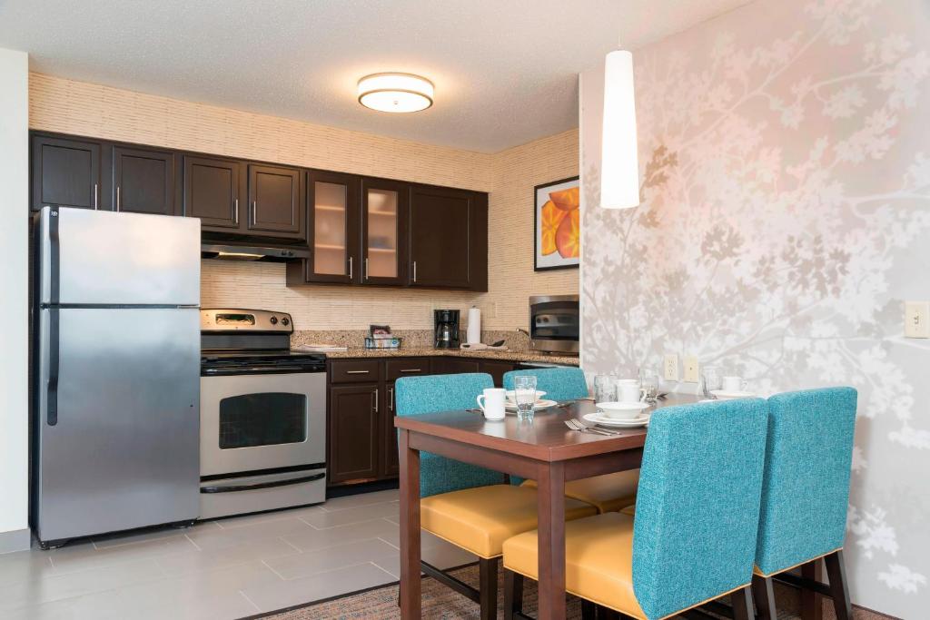 大急流城Residence Inn by Marriott Grand Rapids West的厨房配有桌子和冰箱