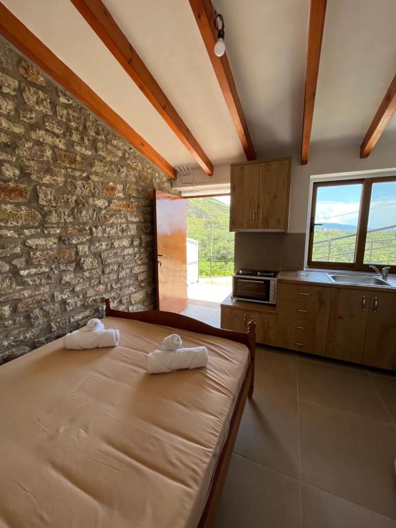 科帕罗KAFUL APARTMENTS的一间卧室设有一张床和石墙