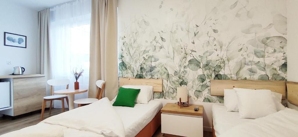 波兰尼卡-兹德鲁伊Zielona Noc的酒店客房设有两张床,墙上挂有绘画作品