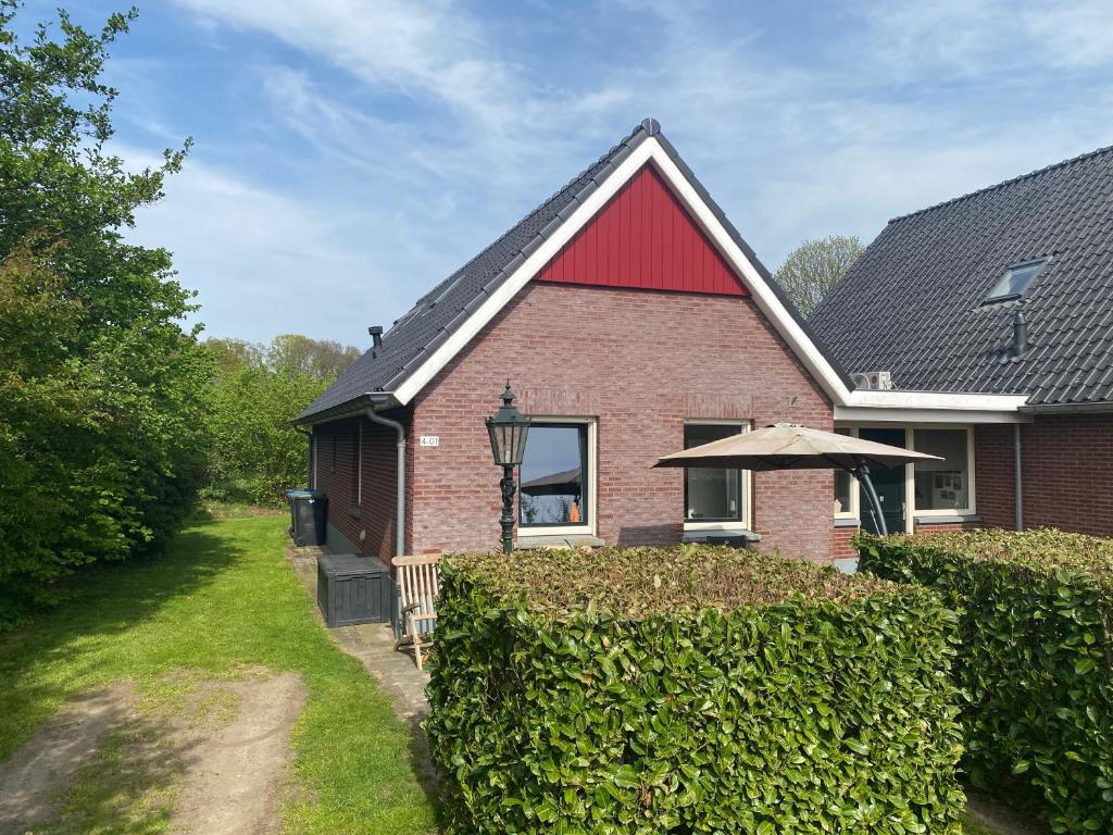 阿尔滕De Daalse Oase的树 ⁇ 上方的红砖房子,有雨伞