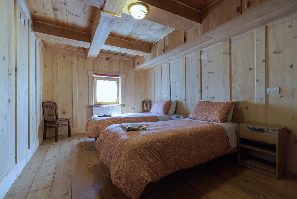 福尔马扎La WalserHus的木墙客房的两张床