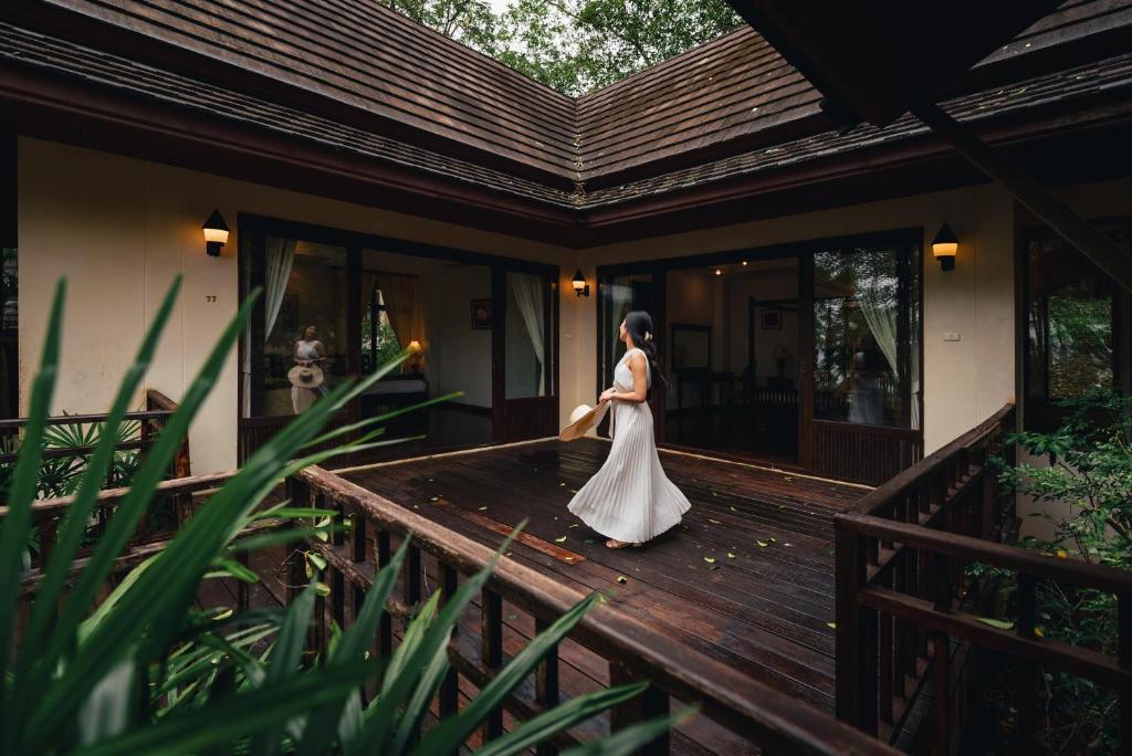 象岛Kooncharaburi Resort - Koh Chang的穿着婚纱的女人在木甲板上行走