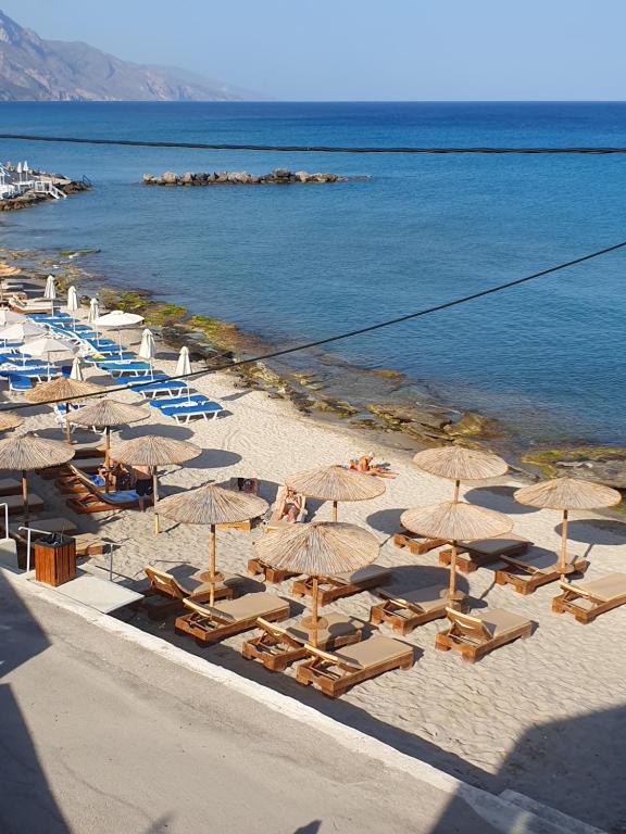 卡尔扎迈纳Sandy feet comfort suite的享有海滩的空中景致,配有遮阳伞和椅子