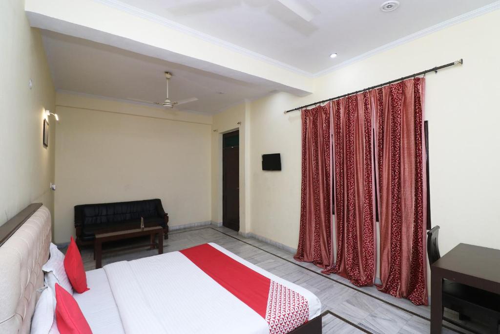 巴雷利OYO Hotel Ayaan的一间卧室配有一张床、一张书桌和一个窗户。
