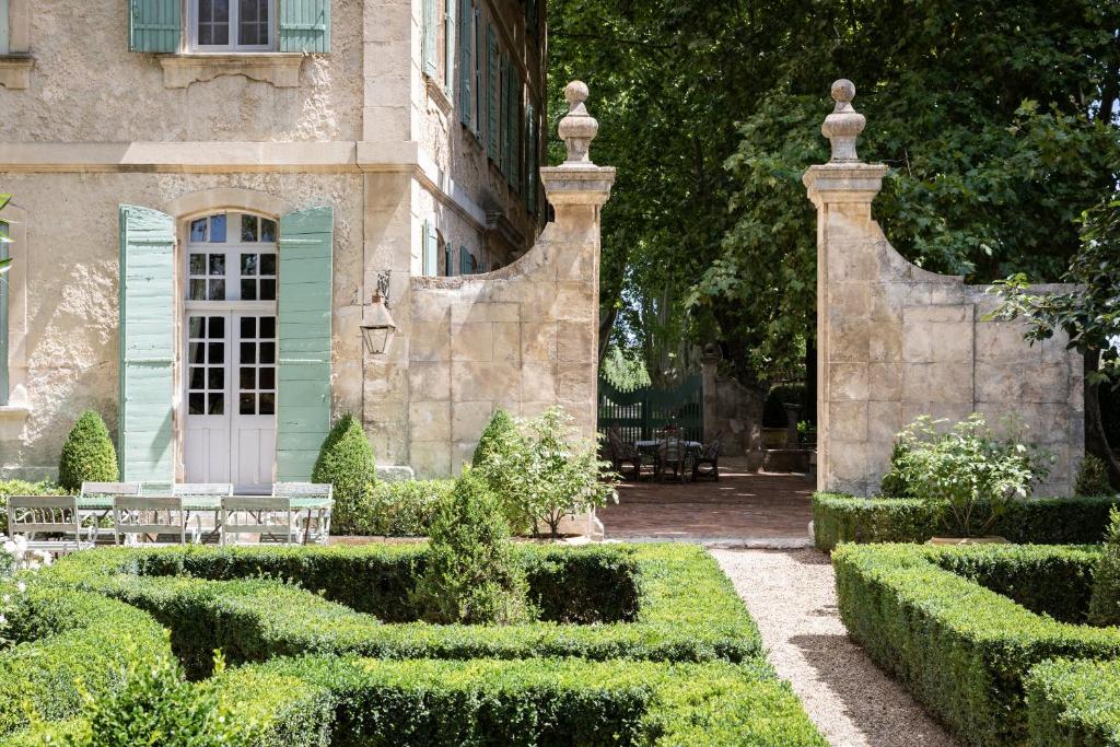 圣雷米普罗旺斯Domaine de Chalamon的一座带长椅和灌木的花园的房子
