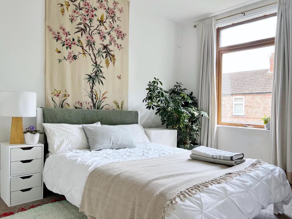 曼彻斯特Beautiful Private Room in Levenshulme的一间卧室配有一张带花卉壁纸的床