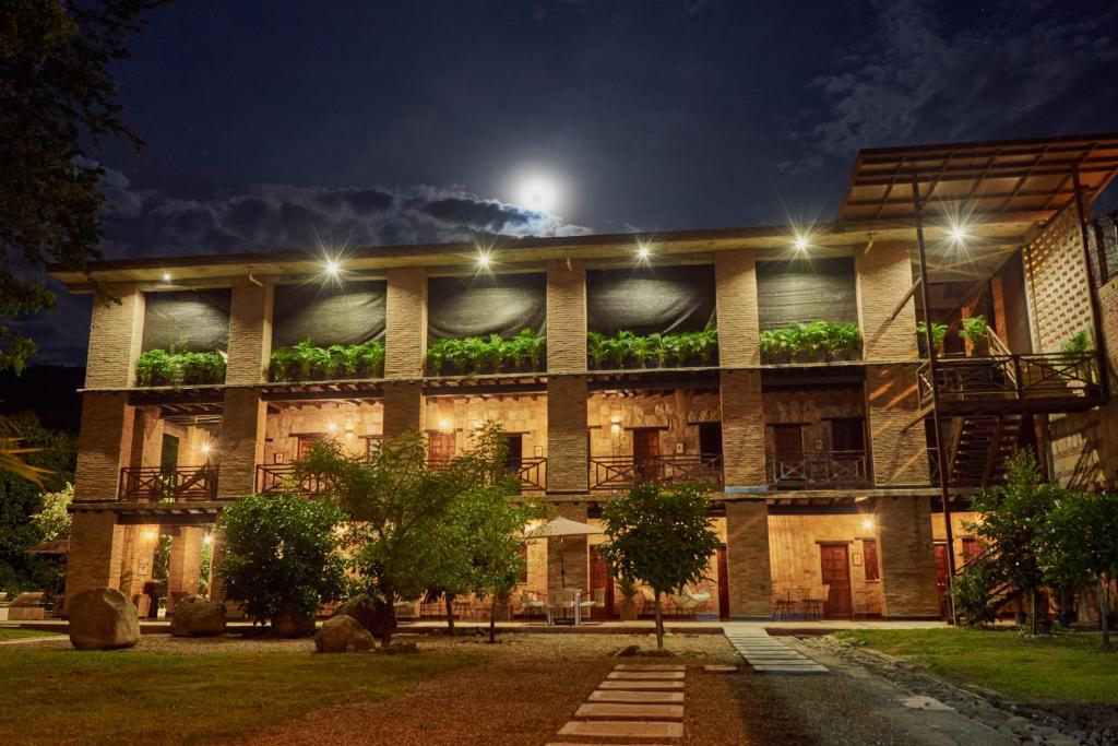 瓜杜阿斯Mentto Hotel的一座在晚上有植物的建筑
