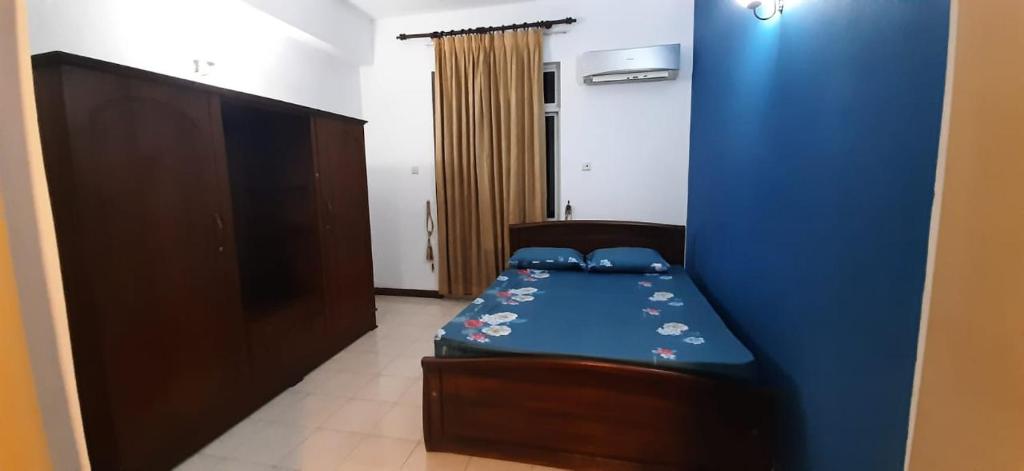 科伦坡Rudra Residence Apartment的一间卧室设有一张床和蓝色的墙壁