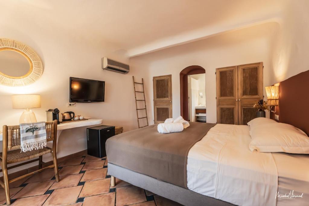 维琪奥港Hôtel Palombaggia的一间卧室配有一张床、一张书桌和一面镜子