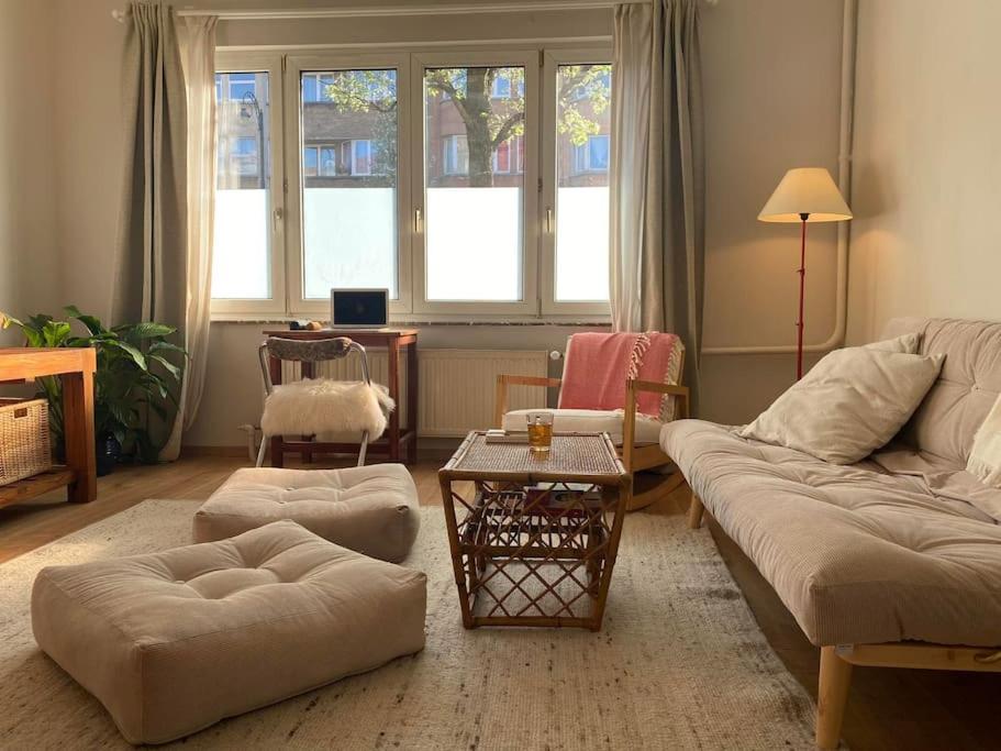 布鲁塞尔Superbe appartement avec jardin, sauna et jacuzzi的客厅配有沙发和桌子