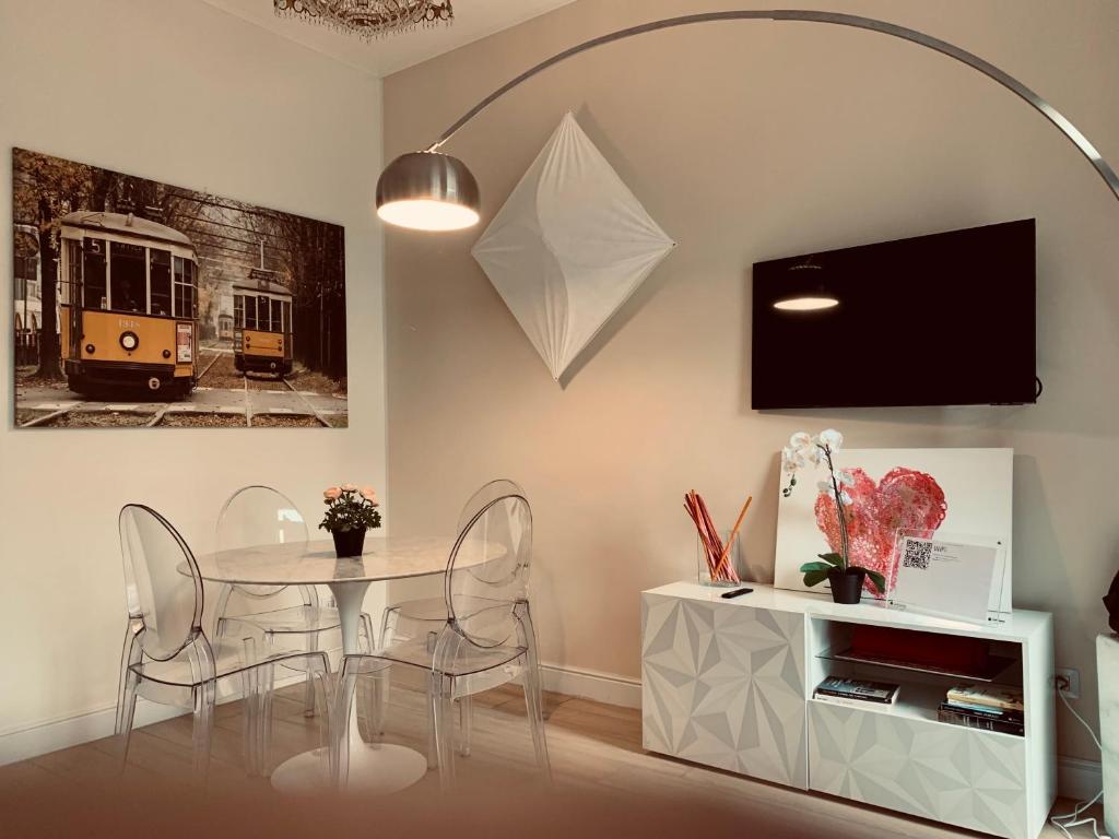 米兰Scarlatti Luxury apt. - B. Aires / Central Station的一间带桌椅和电视的用餐室