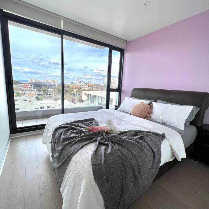 墨尔本Carlton Stunning View Apartment with Free Parking -2的一间卧室设有一张大床和大窗户
